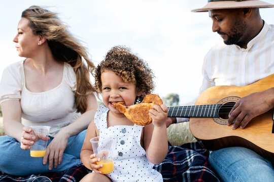 Happy multiethnic family having picnic in nature