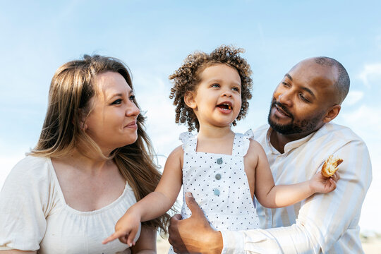 Smiling Multiracial Family Having Picnic In Summer