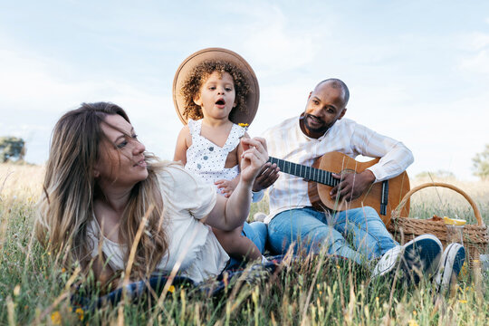Happy multiethnic family having picnic in nature - Powered by Adobe