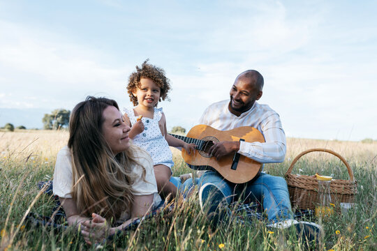 Happy multiethnic family having picnic in nature