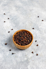 Cubeb pepper in a small bowls and spoon.