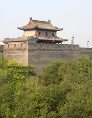 Fototapeta premium City Wall, Xian, Shaanxi Province, China. The City Wall of Xian is one of the largest and best preserved city fortifications in China. Watchtower on Xian city wall overlooking trees.