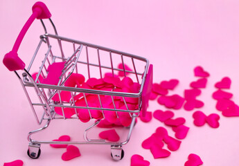 Selective focus. shopping cart filled with red hearts on a pink background. Decorative basket with small hearts. The concept of gifts to a loved one, love. High quality photo