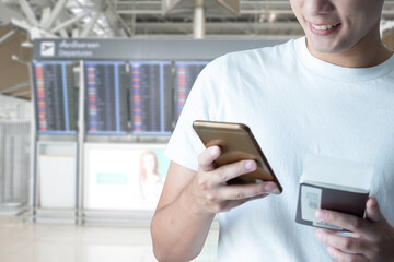 man smile checking e-mail on mobile phone while walking in airport, male  using cell telephone 