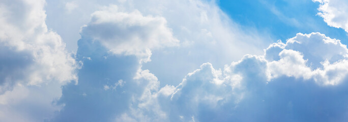 Naklejka na ściany i meble Blue sky with whimsical clouds in sunny weather