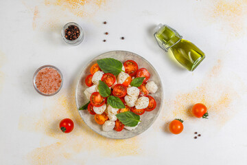 Delicious Italian Caprese salad with sliced red and orange cherry tomatoes.