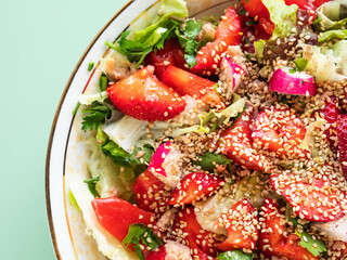 Fresh summer healthy fiber protein vitamin salad in bowl with strawberries, lettuce, tuna, tomatoes