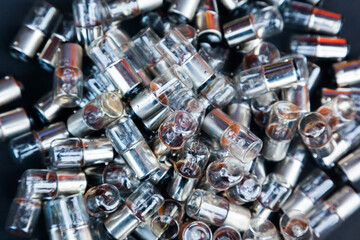 Many small incandescent bulbs lie in a heap, close-up.