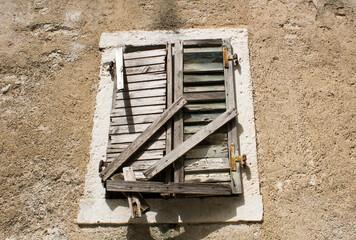 Close-up on old boarded up wooden window on the facade of the house