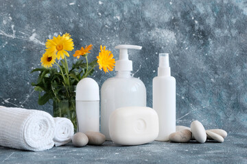 Obraz na płótnie Canvas Spa set on a gray beautiful background. White towels, bottles, soap, leaves, natural cosmetics, shells, stones. Spa concept, beauty salon, body care