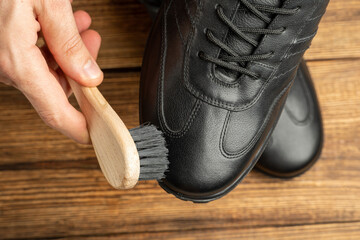 cleaning, polishing, restoration black leather boots with brush and footwear care product, shoe polish