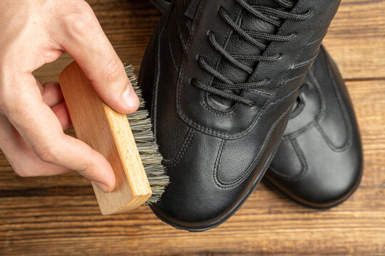 cleaning, polishing, restoration black leather boots with brush and footwear care product, shoe polish