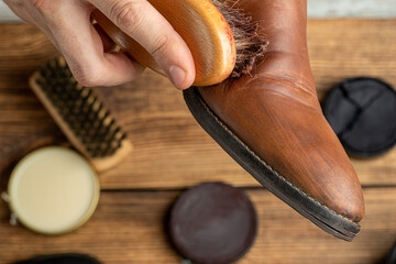 cleaning, polishing, restoration brown leather boots with brush and footwear care product, shoe...