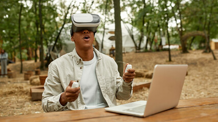 African american man wearing virtual reality glasses and gamepads