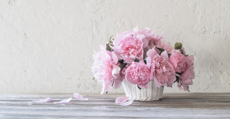 pink peony in  basket  on background old wall