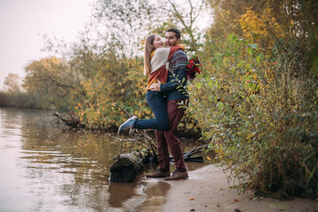 A romantic date, a walk in nature. Young couple of lovers together on the lake in early autumn