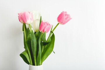 Pink tulips bouquet on white background with copy space. Bouquet of Beautiful pink and white spring tulips flowers for Mothers Day, Valentine Day, birthday concept, Hello spring.