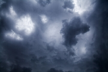 Atmospheric futuristic picture of clouds before the storm creates unreal blurred black and white natural background texture. The darkest cloud has an original figure and dominates in the foreground.