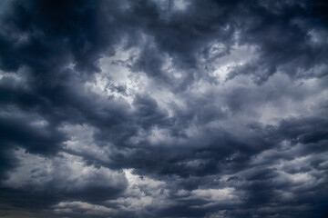 Stormy black clouds close the sky to the horizon. Dark thunderstorm clouds all over sky create an incredibly menacingly beautiful pattern.