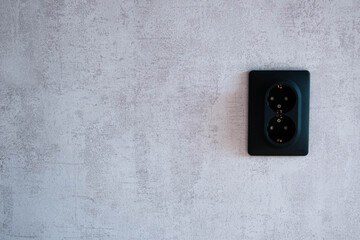 Black socket on a gray wall. Loft.
