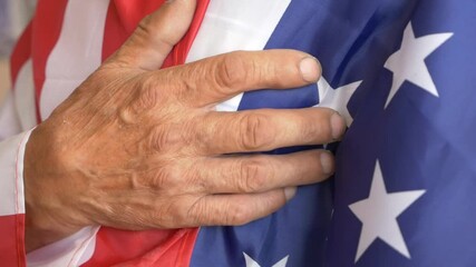 Close-up of a man wrapped in the national flag of america and sings the anthem in all honesty. Us patriot with flag at independence day. Celebrating America's Independence Day. selective focus