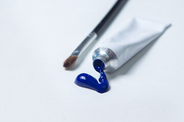 Brush for painting with blue paint on a white background. Watercolor paint