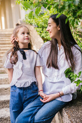 Naklejka premium A young mother holds her little daughter's hand and talks. The concept of a strong family.