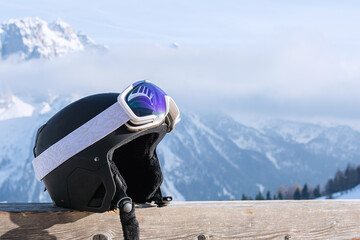 View of a ski helmet with sunglasses on the background of snow-capped mountains. Landscape, industry, sports concept