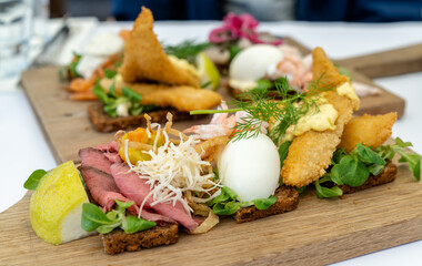 close up view of delicious Smørebrød sandwiches on a wooden platter as a typical Scandinavian...