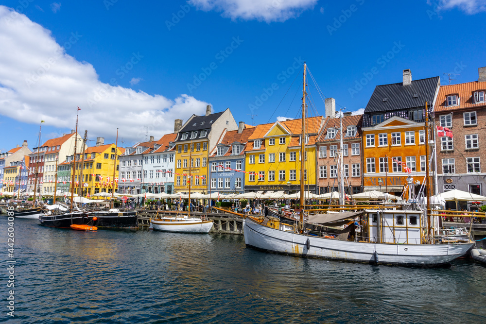 Poster fishing boats and river barges in the colorful Nyhavn area of downtown Copenhagen