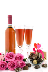 A glasses of wine, gift, roses and chocolate pralines