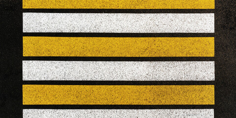 pedestrian crossing with white and yellow lines on asphalt - obrazy, fototapety, plakaty