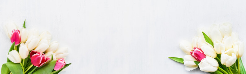Fototapeta premium Two bouquets of white and red tulips on a white background. Flat lay, banner