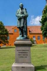 Fototapeta premium statue of Hans Christian Andersen in the park of Saint Canute Cathedral in downtown Odense