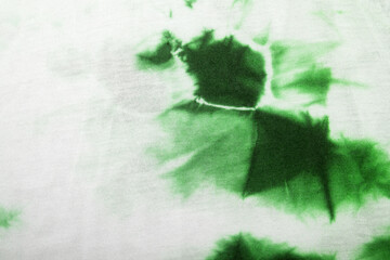White fabric with green tie dye stain. Background or texture.