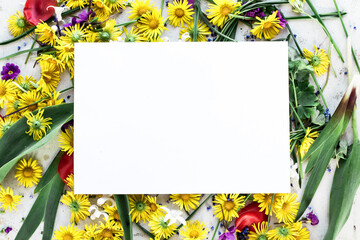 Blank craft business card mockup with fresh flowers. Flat lay, top