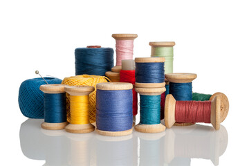 Spools of thread, bobbins with threads of different colors and sizes, cotton and synthetic threads for sewing, insulated on a white background