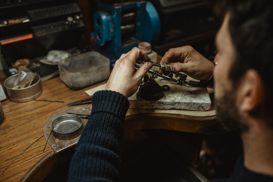 Goldsmith inspecting ring at workshop