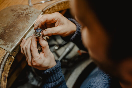 Goldsmith inspecting ring at workshop