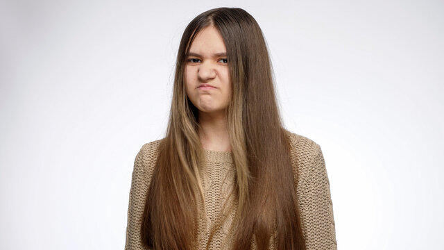 Studio portrait of displeased girl shaking head and saying no. Denial sign