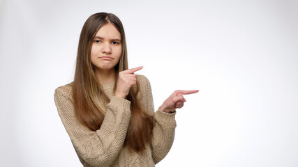 Portrait of confident grl pointing on the invisible product on her side. Place your product or object. Advertising template.