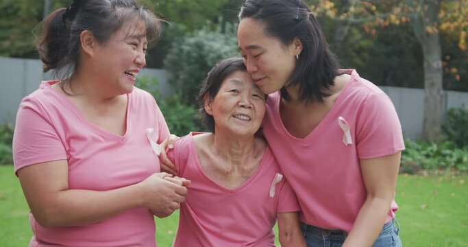 Happy asian adult granddaughter, mother and grandmother, walking and embracing in garden