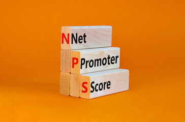 NPS net promoter score symbol. Wooden blocks with words 'NPS net promoter score'. Beautiful orange background. Business and NPS net promoter score concept. Copy space.