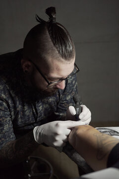 Master making tattoo on skin of client
