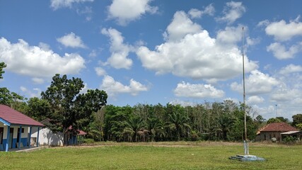 a very beautiful clear sky over a school building in a village.