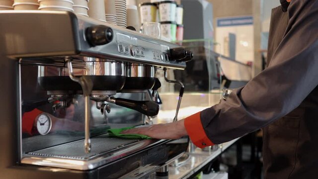 Male worker working with coffee equipment and standing in kitchen of cafe spbi.