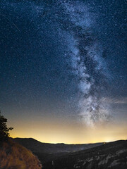 Milky Way with center over hill landscape with rock formation in Provence, France