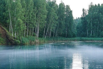 Obraz premium Fog on a blue lake of amazing beauty. non-freezing water