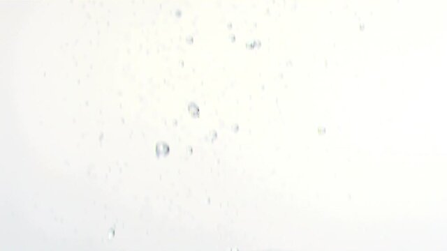 Animation of uncut diamonds falling and red confetti floating up, on white background