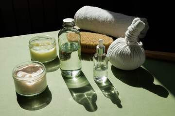 Body treatment and spa concept. Scrub, mask, cream and natural oil cosmetics on green background....